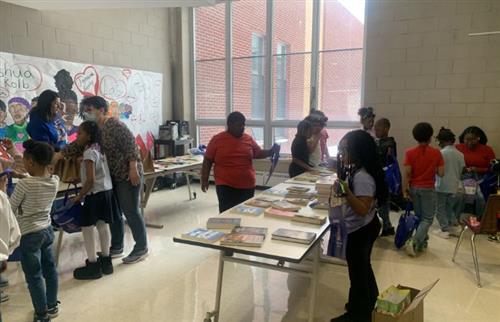 Students picking out books donated by the 40 and over Double Dutch Team
